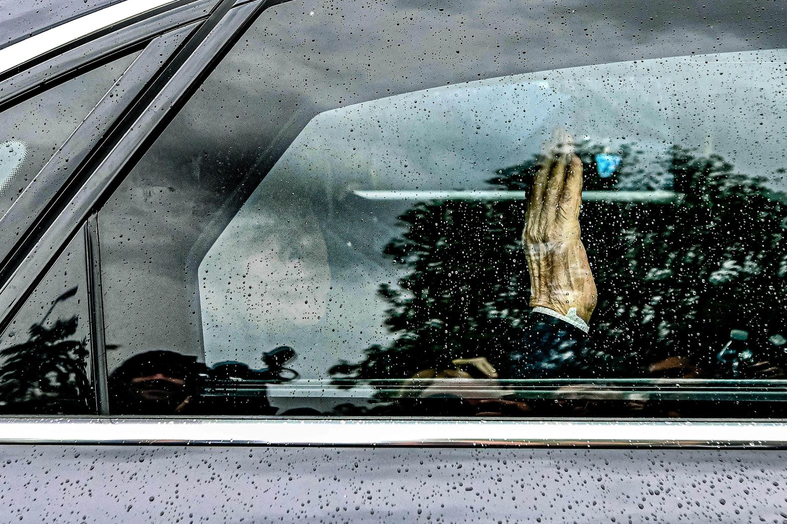 Berlusconi waves from inside a car after being discharged from a hospital in Milan on May 19.