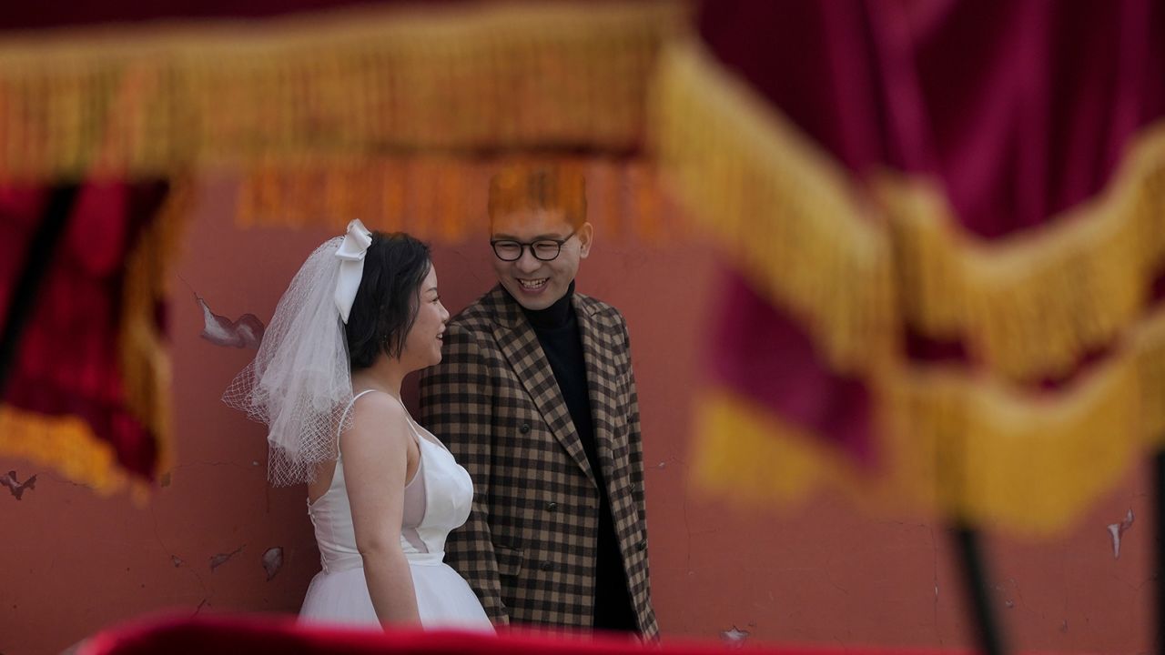 A bride and groom stand together before posing for a pre-wedding photo shoot in Beijing earlier this year.