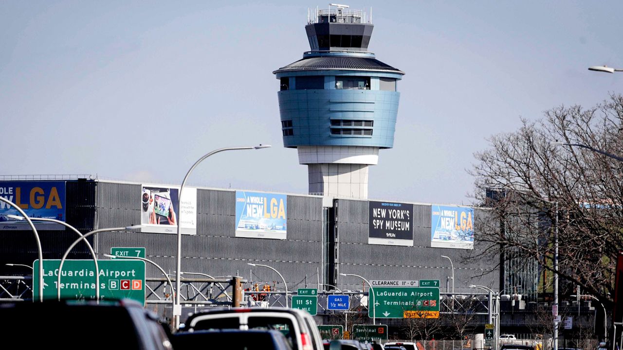 FILE - LaGuardia Airport's air traffic tower looms in view of passing traffic on Jan. 25, 2019, in New York. The Port Authority of New York and New Jersey released more than a dozen options on Wednesday, Mach 2, 2022, for a public transit connection between Manhattan and LaGuardia Airport that include light rail, express buses, ferries and the extension of subway lines. (AP Photo/Julio Cortez, File)