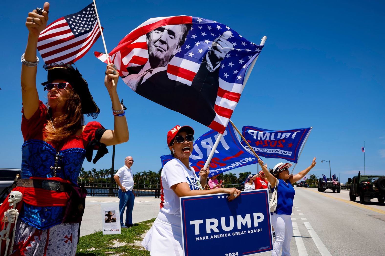 Trump supporters wave flags outside the Mar-a-Lago Club in Palm Beach, Florida, on Sunday, June 11.