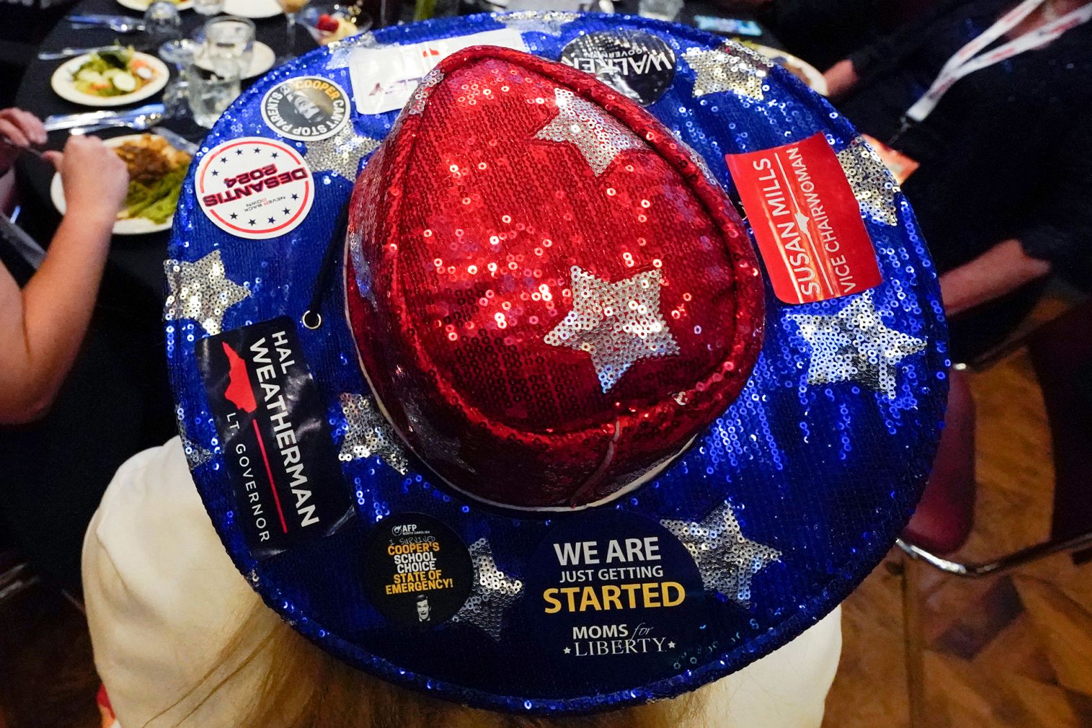 A woman wears a hat with campaign stickers on it during the Republican Party convention in Greensboro, North Carolina, on June 10.