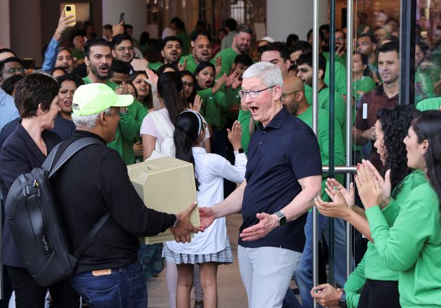 Cook reacts after seeing a Macintosh SE computer held by Sajid Moinuddin, a fan of Apple products, during the inauguration of India's first Apple retail store in Mumbai in April 2023.