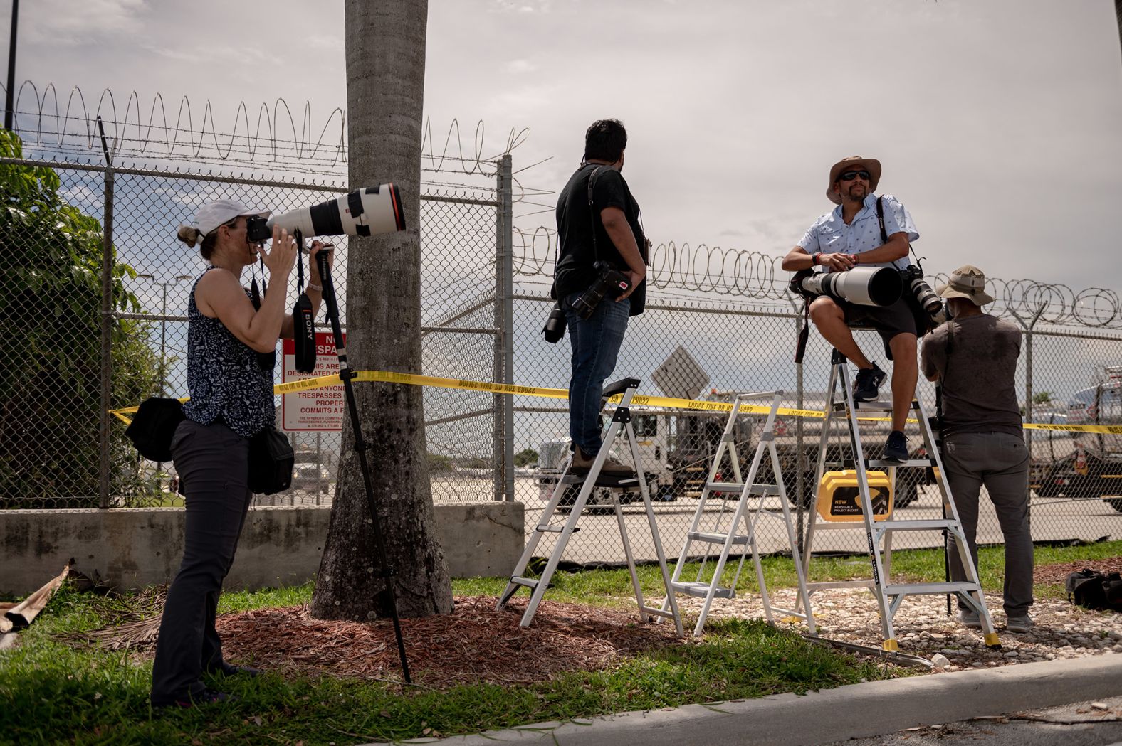 Press photographers wait for Trump to land in Miami.