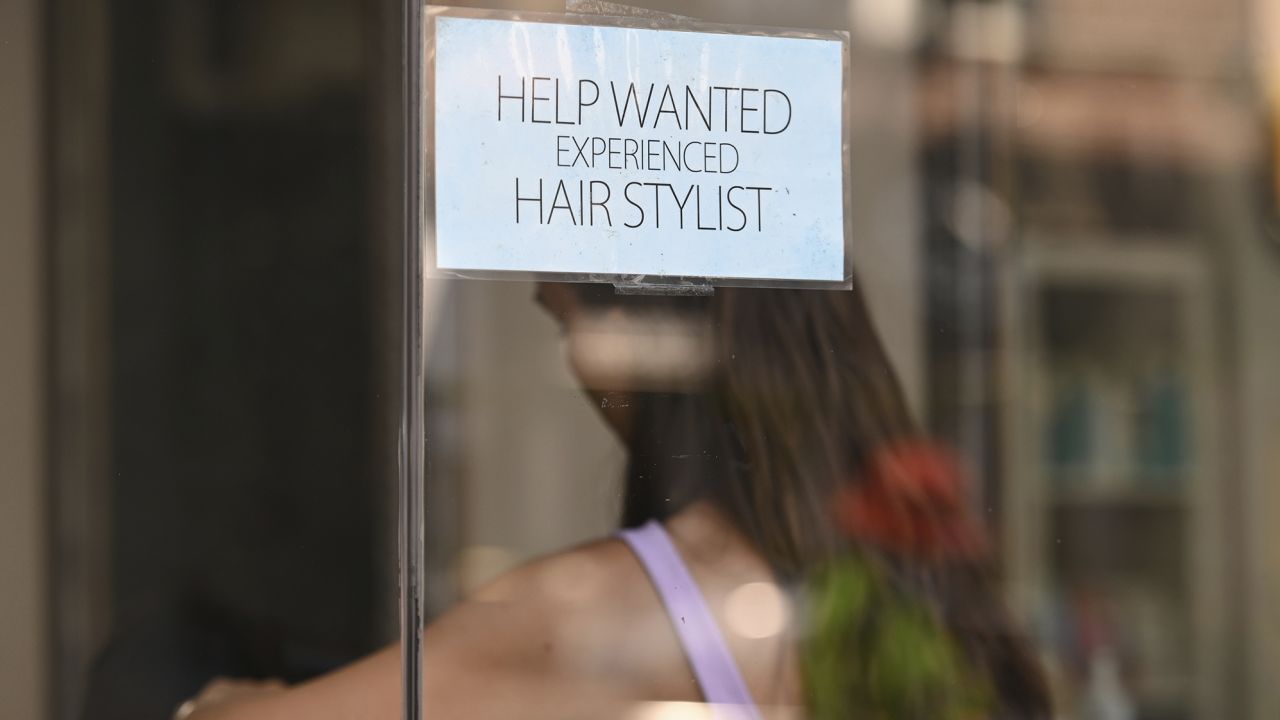 A hiring sign is taped to the window of a hair salon in the New York City borough of Queens, NY, August 4, 2022. 