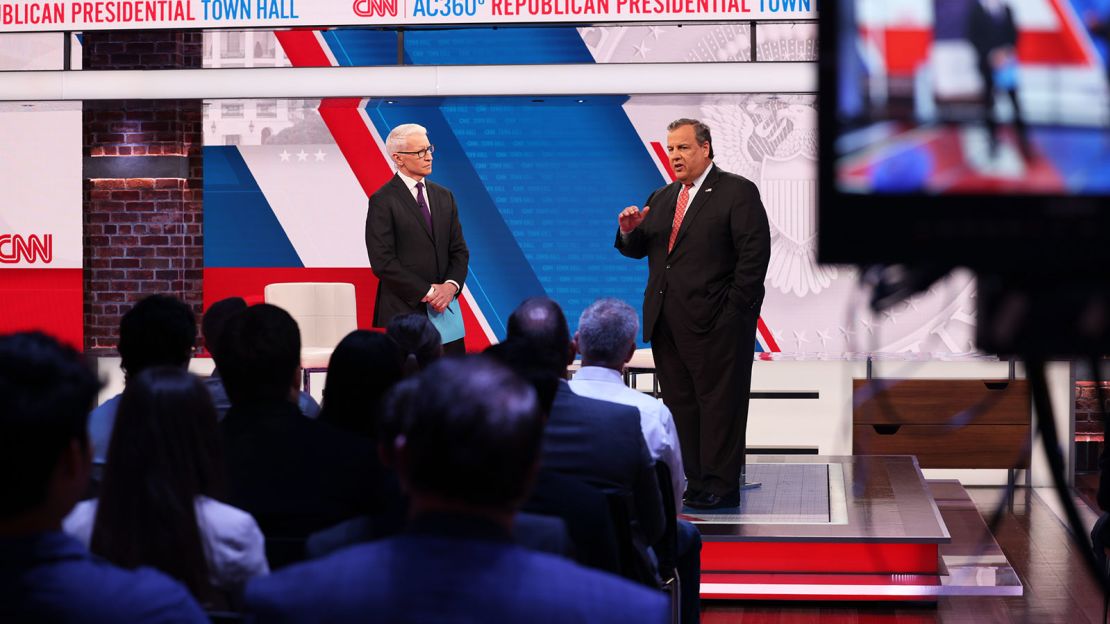 Cooper listens as Christie answers a question during the town hall.