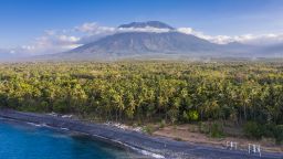 Aerial landscape taken by drone of the northern coastline of Bali in Indonesia with the Mount Agung volcano sitting on the horizon.