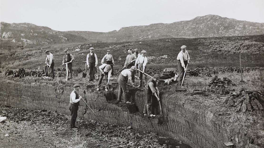 Islay’s tradition of whisky-making goes back generations. Pictured here, circa 1912, are workers hand-cutting peat that is burned in the kilns to dry the barley.