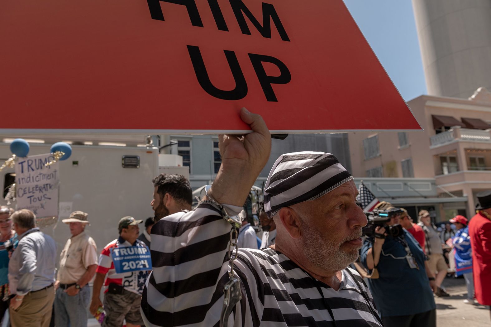 A man with a sign reading "lock him up" demonstrates outside the courthouse on June 13.