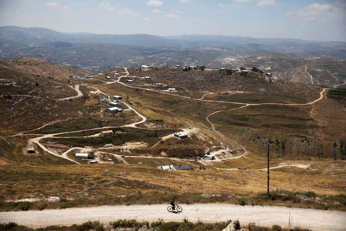 A youth rides a bicycle on a road in the Jewish settlement of Yitzhar, in the occupied West Bank, in June 2020.