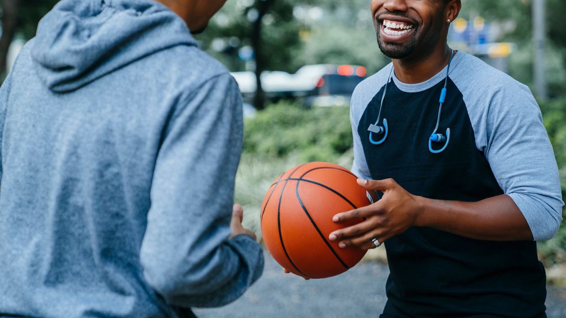 Smiling Black men playing basketball