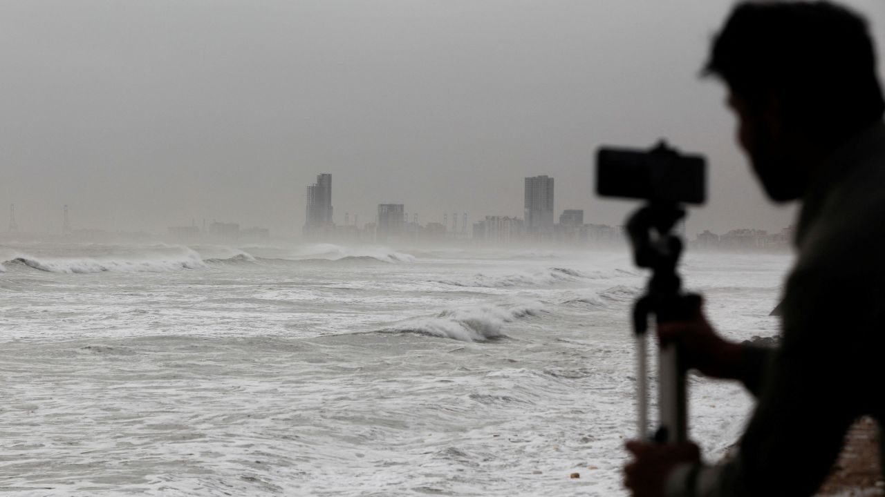 کراچی، پاکستان کے کلفٹن بیچ پر، بپرجوئے کی آمد سے پہلے، 13 جون کو ایک شخص سمندر کی فلم بنا رہا ہے۔