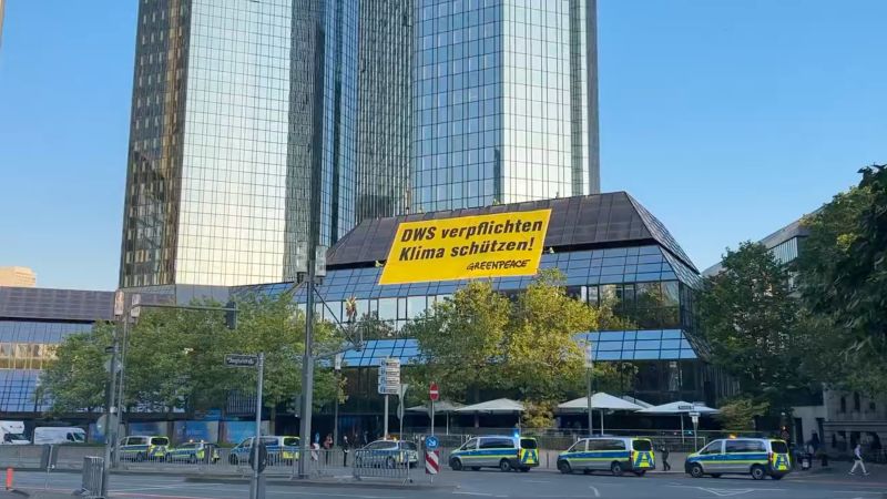 NextImg:Greenpeace activists climb Deutsche Bank HQ in climate protest | CNN Business