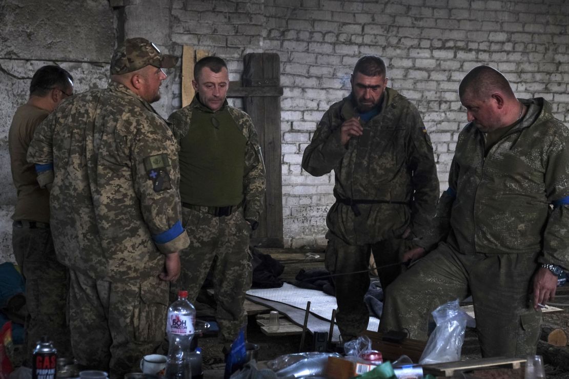 Ukrainian soldiers from the 68th Jaeger Brigade listen to a radio, awaiting news from the frontline.