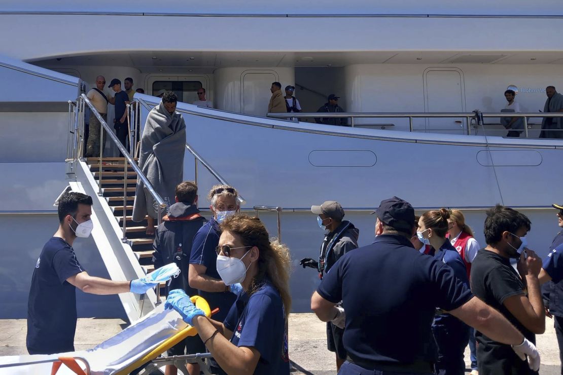 Survivors arrive by yacht after a rescue operation at the port in Kalamata town.
