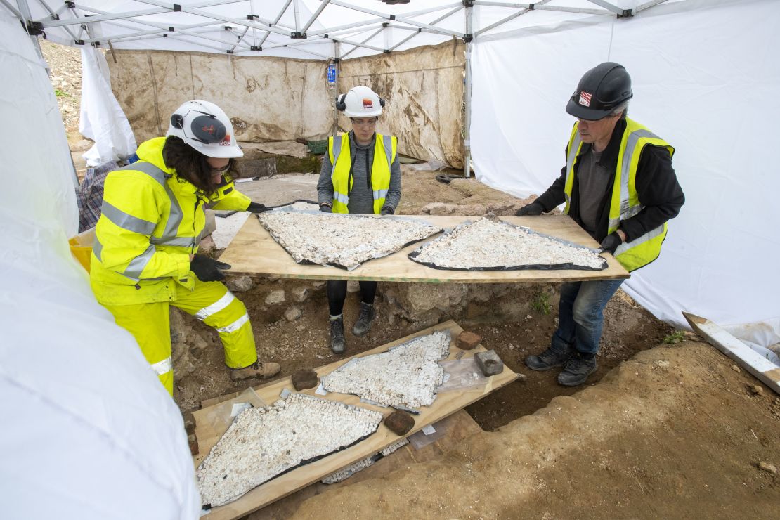 Archaeologists carefully transport pieces of the mosaic. 