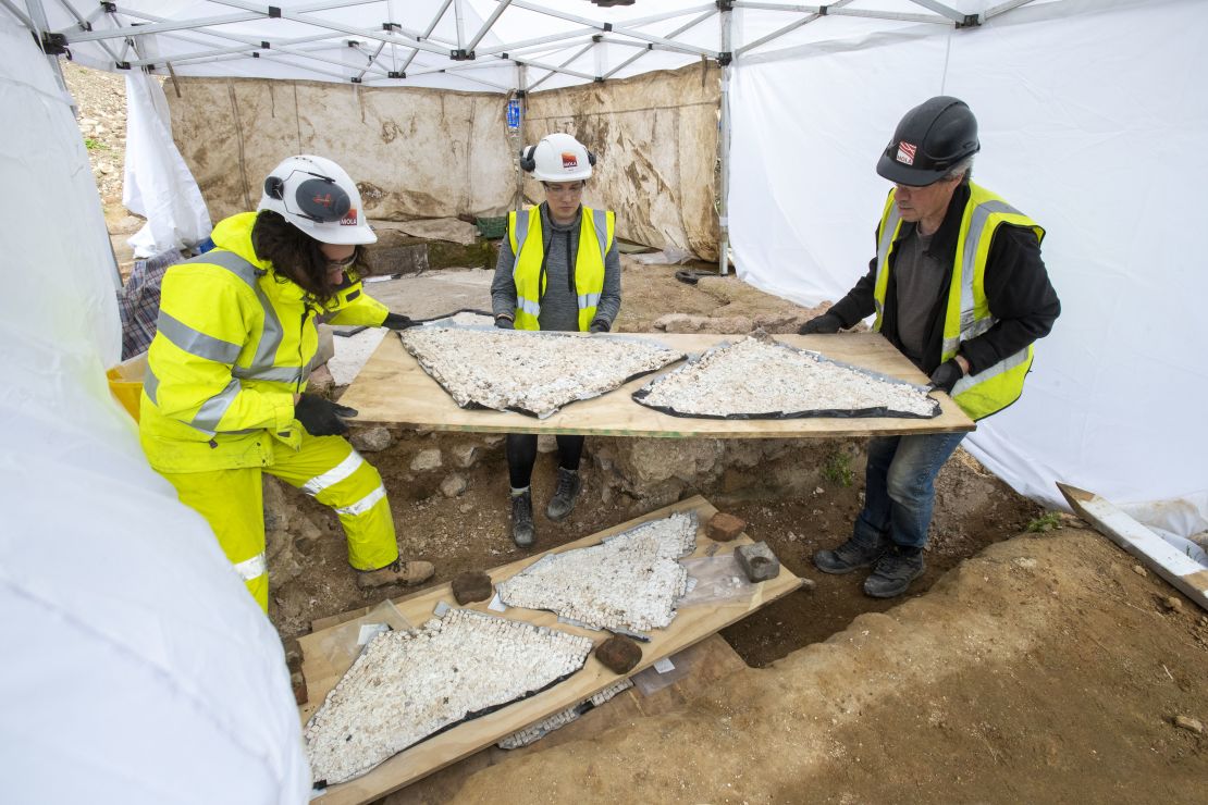 Archaeologists carefully transport pieces of the mosaic.