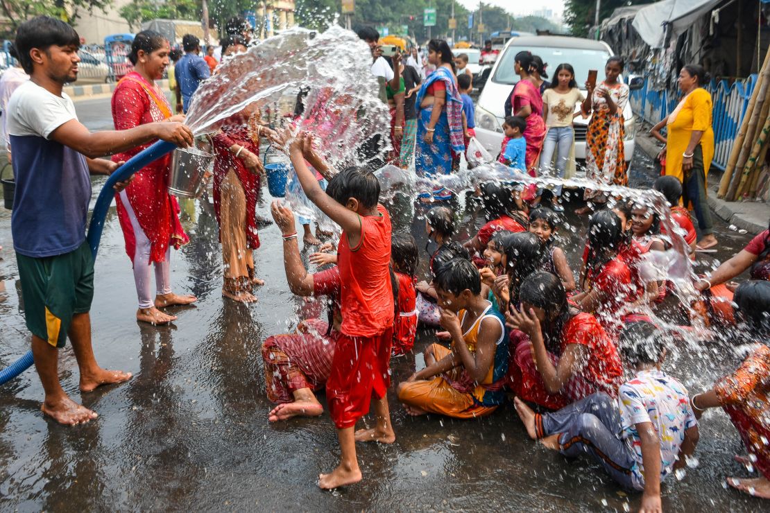 People and children are seen taking baths and filling up containers with water from a municipal tanker on a hot day in Kolkata, India, on April 15th, 2023.