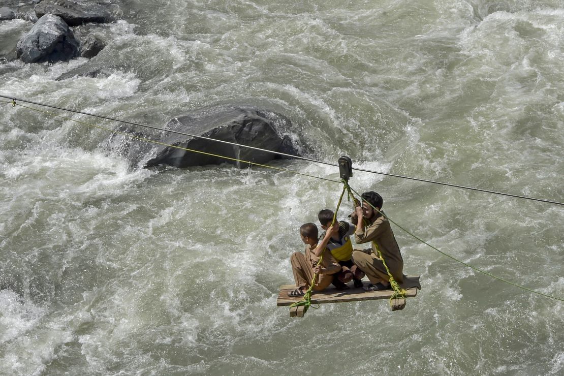 Local residents cross the river Swat after heavy rains in Bahrain town of Swat valley in Khyber Pakhtunkhwa province, Pakistan, on August 31, 2022.