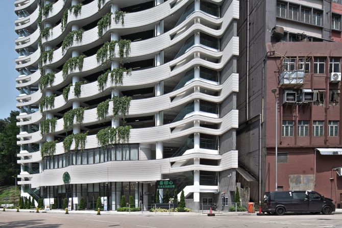 The fan-shaped building stands in sharp contrast to other buildings in the industrial district of Kwai Chung in Hong Kong.