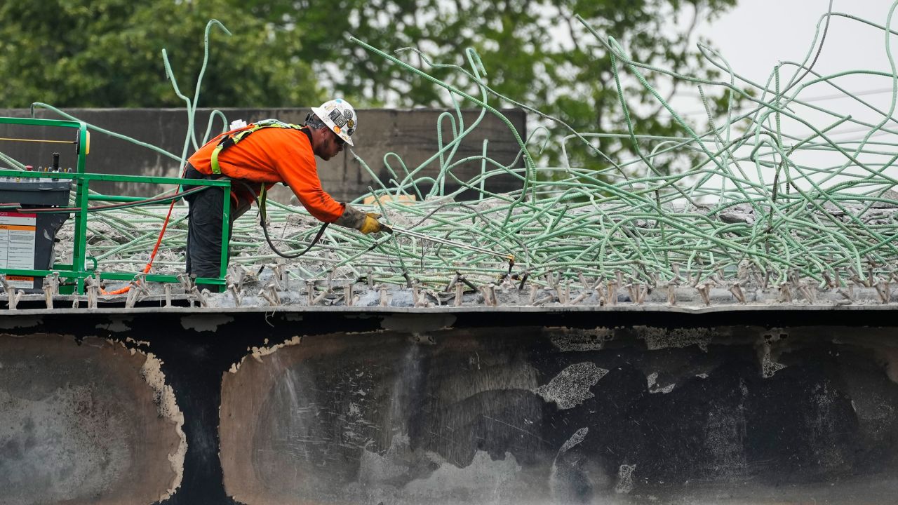 A construction worker cuts rebar at the scene of the collapse.