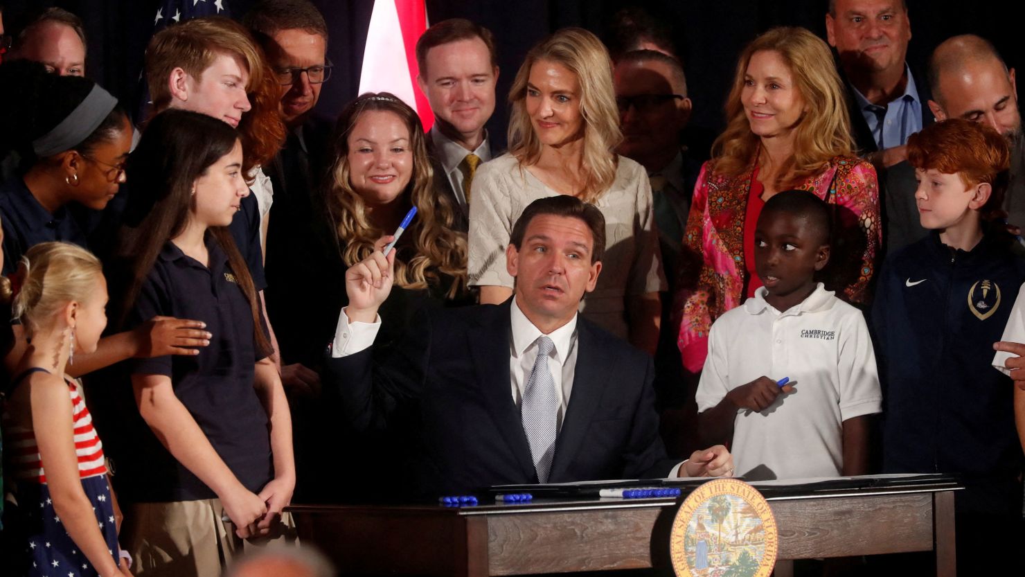 Florida Governor Ron DeSantis holds up his pen while signing five state house bills into law after giving a press conference at Cambridge Christian School in Tampa, Florida, in May.