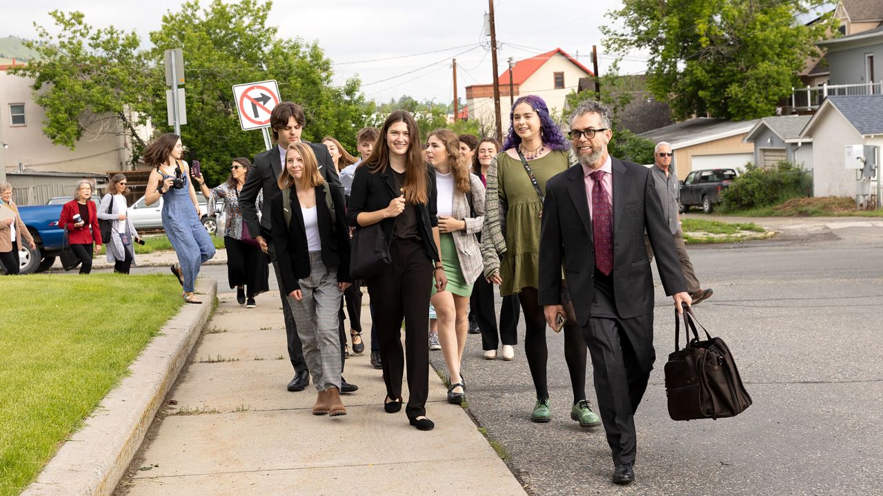 Rikki Held, center, and Olivia Vesovich, second from right, who are among a group of young people suing the state government, walk towards a courthouse in Helena, Montana, on June 12. Sixteen young people argue that the state is robbing their future by embracing policies that contribute to climate change.