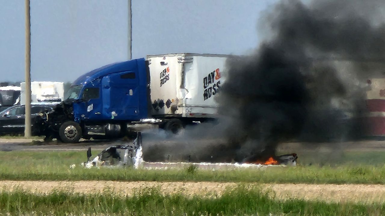 Smoke comes out of a car following a road accident that left 15 dead near Carberry, west of Winnipeg, Canada, on Thursday.