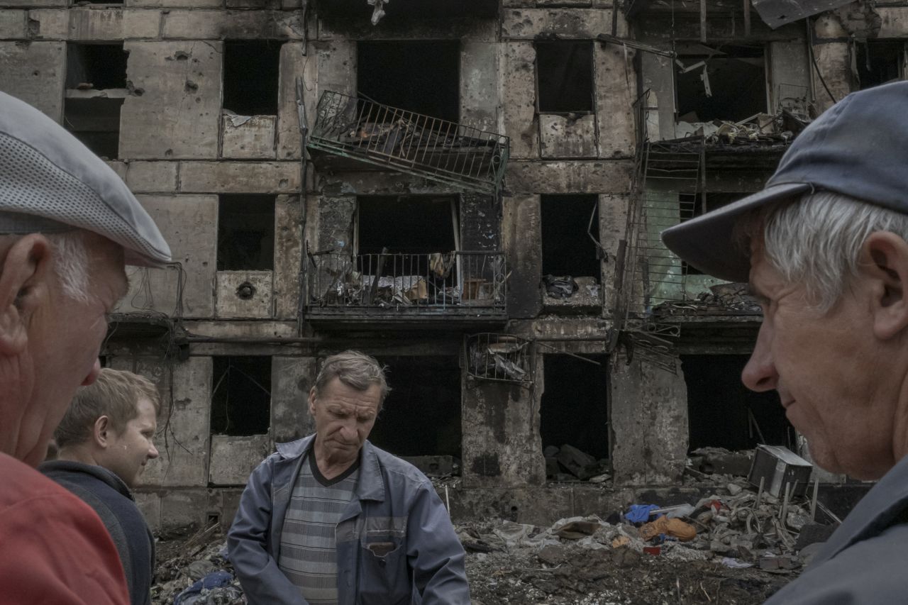 Workers take a break outside an apartment building that had been <a href="https://www.cnn.com/europe/live-news/russia-ukraine-war-news-06-15-23/h_ea1921b08abd3dcd863f79bd2d4f91e6" target="_blank">hit by a Russian missile strike</a> in Kryvyi Rih, Ukraine, on Tuesday, June 13. At least 11 people were killed in the attack.