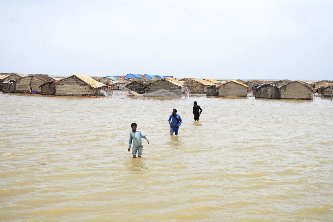 People in Pakistan's Sujawal District wade through water as <a href="https://www.cnn.com/2023/06/14/asia/india-pakistan-cyclone-biparjoy-evacuations-intl-hnk/index.html" target="_blank">Cyclone Biparjoy</a> pounded the country's coastline on Thursday, June 15.