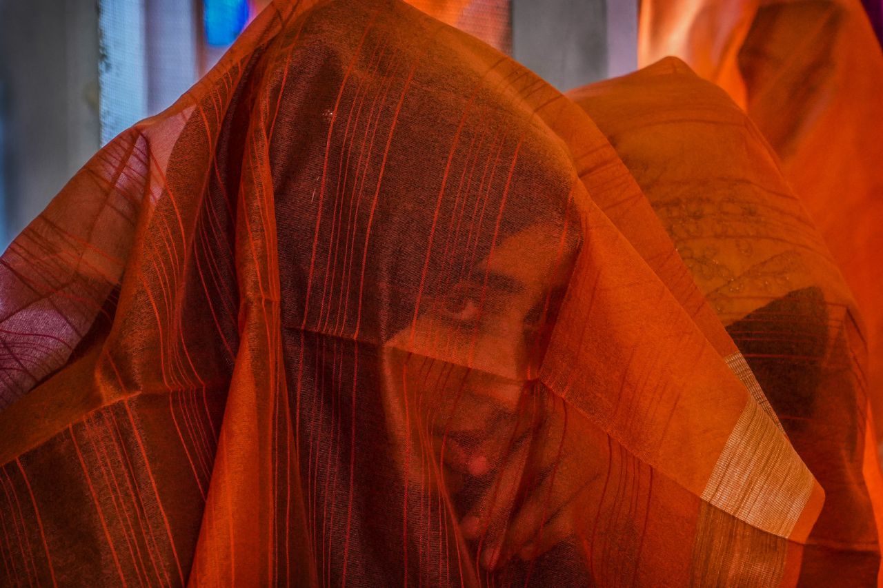 A Kashmiri Muslim bride looks through her veil during a mass wedding in Srinagar, India, on Thursday, June 15. Mass weddings in India are organized by social organizations primarily to help families who cannot afford the high ceremony costs as well as the customary dowry and expensive gifts that are still prevalent in many communities.