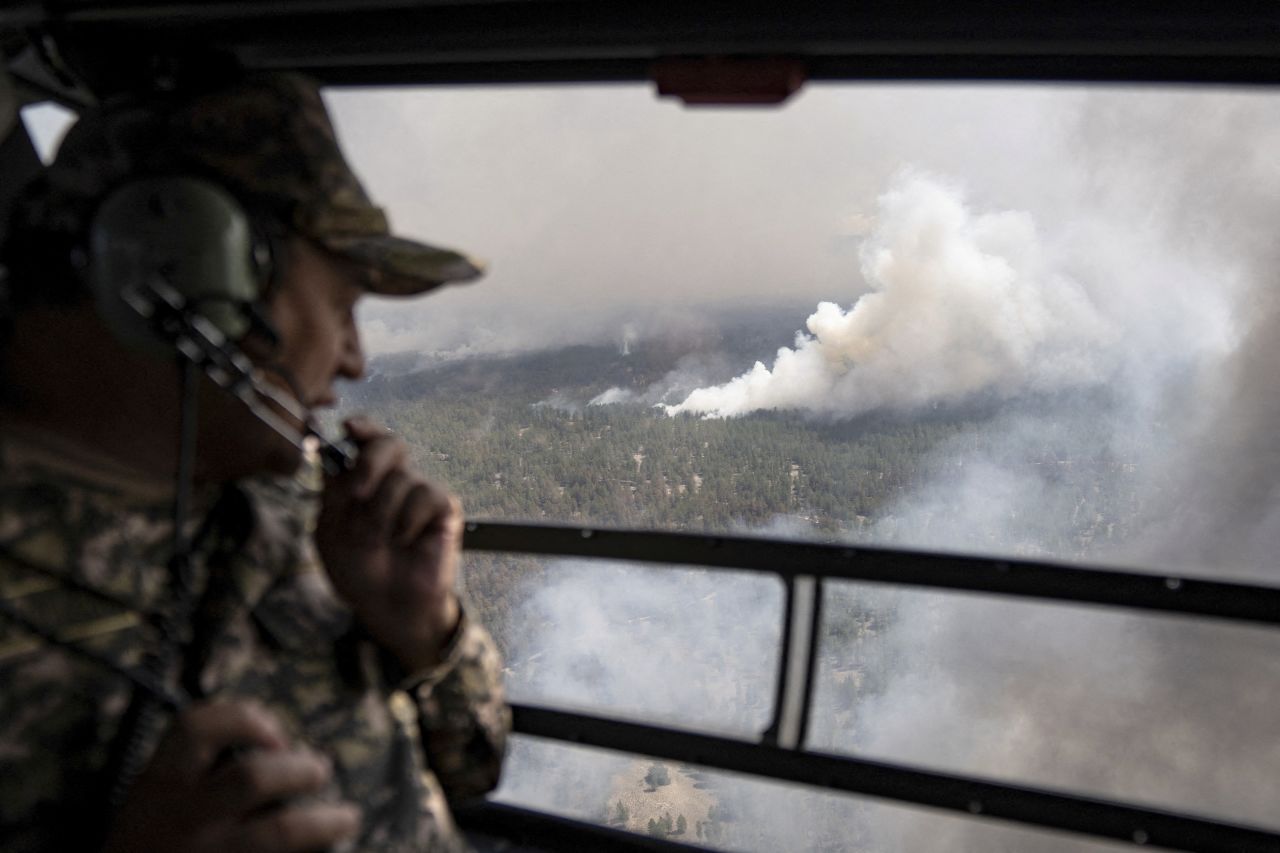 An emergencies ministry specialist flies on a helicopter during an operation to contain wildfires in Kazakhstan's eastern Abai region on Monday, June 12.