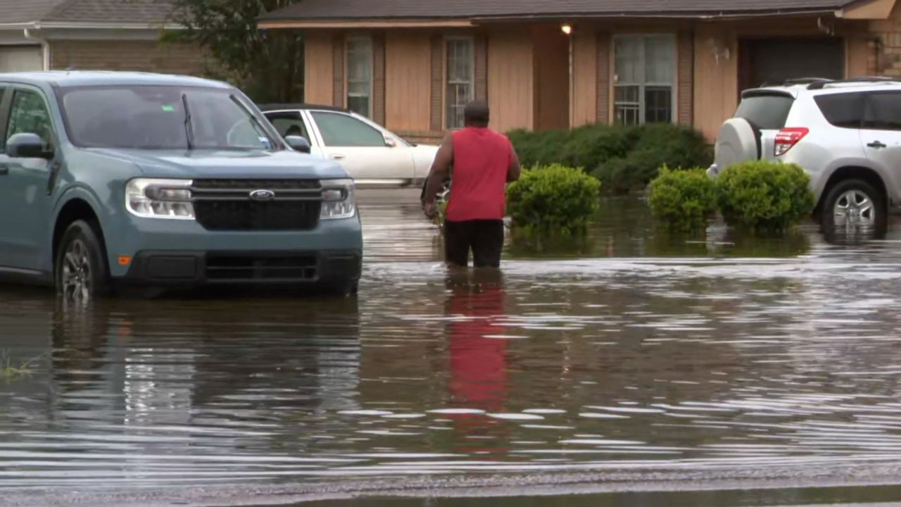 A person walks through floodwater in Pensacola, Florida, Friday.