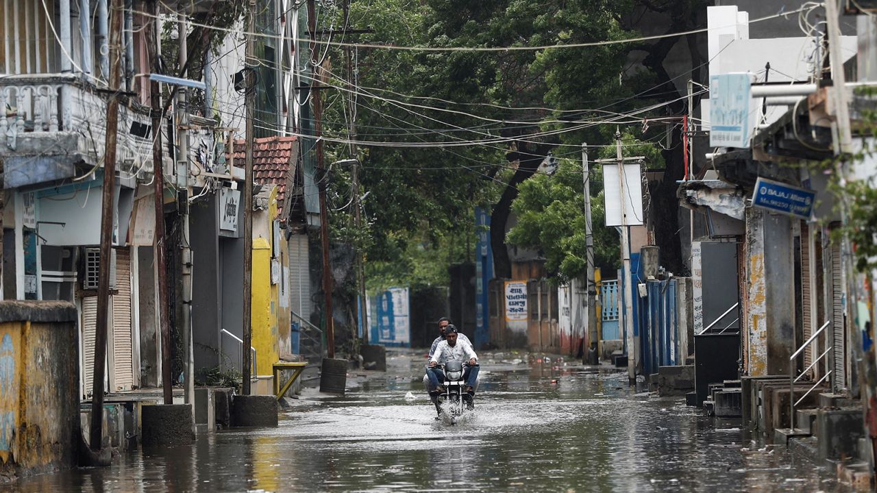 A man rides a motorcycle through a waterlogged street in Mandvi before the arrival of cyclone Biparjoy in the western state of Gujarat, India, June 15, 2023.
