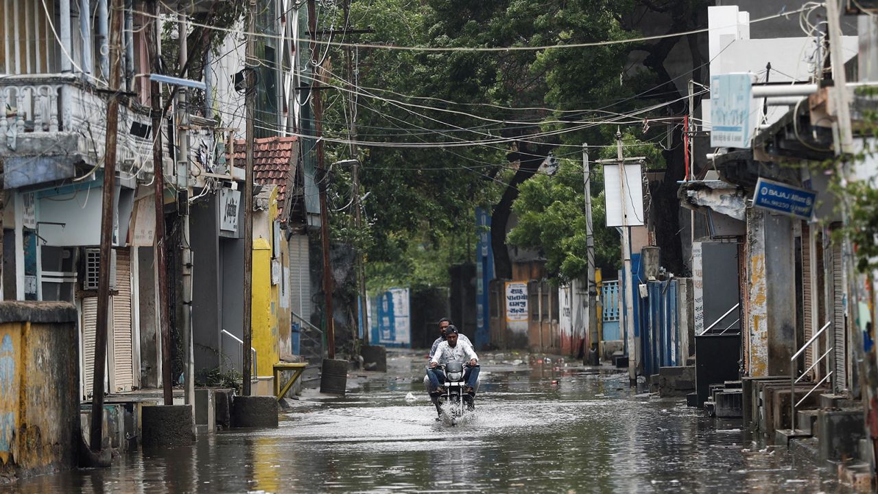 A man rides a motorbike on a water-filled street in Mandvi before the arrival of Cyclone Piparjoy in western Gujarat, India, June 15, 2023. 