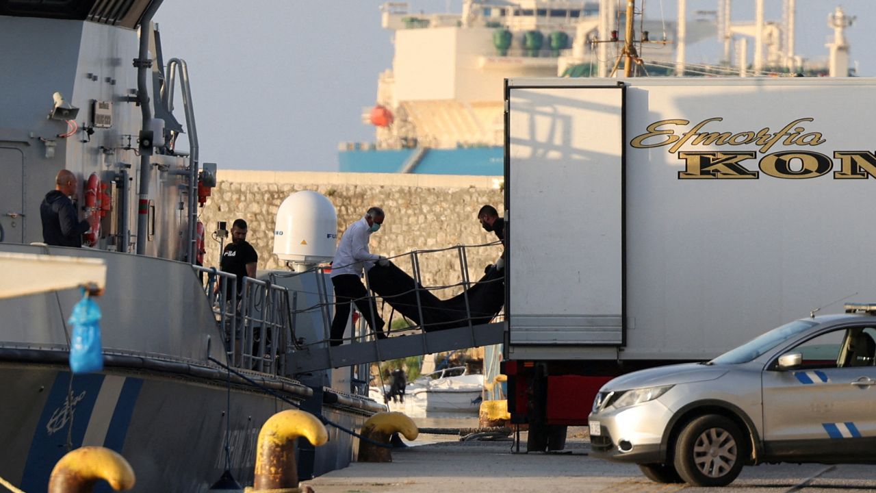 Workers transfer body bags carrying migrants who died after their boat capsized off Greece, on June 15.