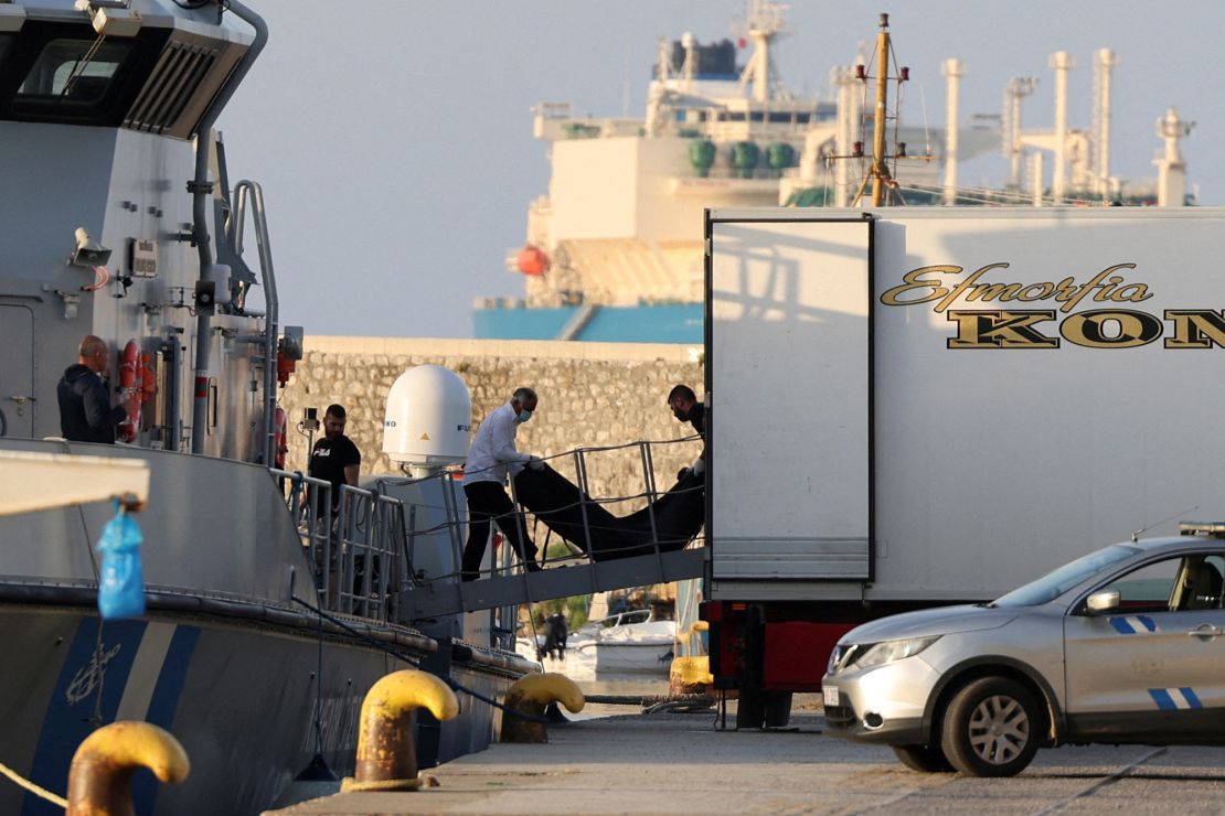Workers transfer body bags carrying migrants who died after their boat capsized off Greece, on June 15.