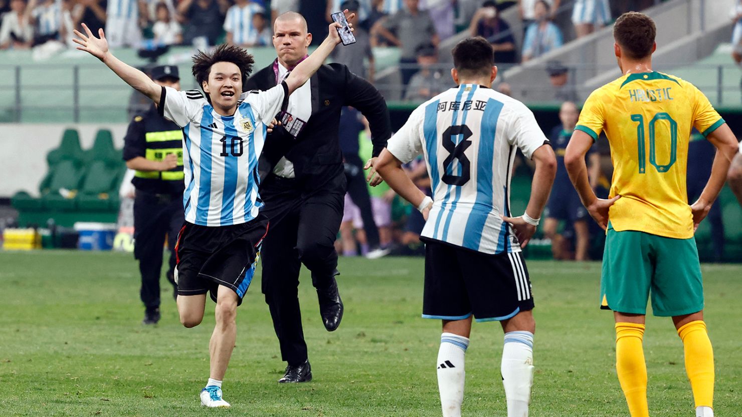 The young pitch invader is chased by security officials during a soccer match between Argentina and Australia at the Workers' Stadium in Beijing, China, on June 15.