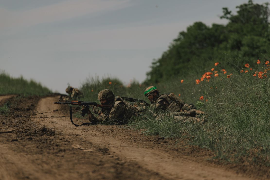 Ukrainian soldiers lie on a roadside during training for an operation near Bakhmut on June 1.