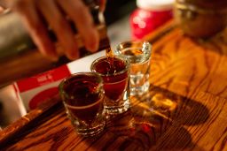 Bartender pouring shots of whiskey into shot glasses