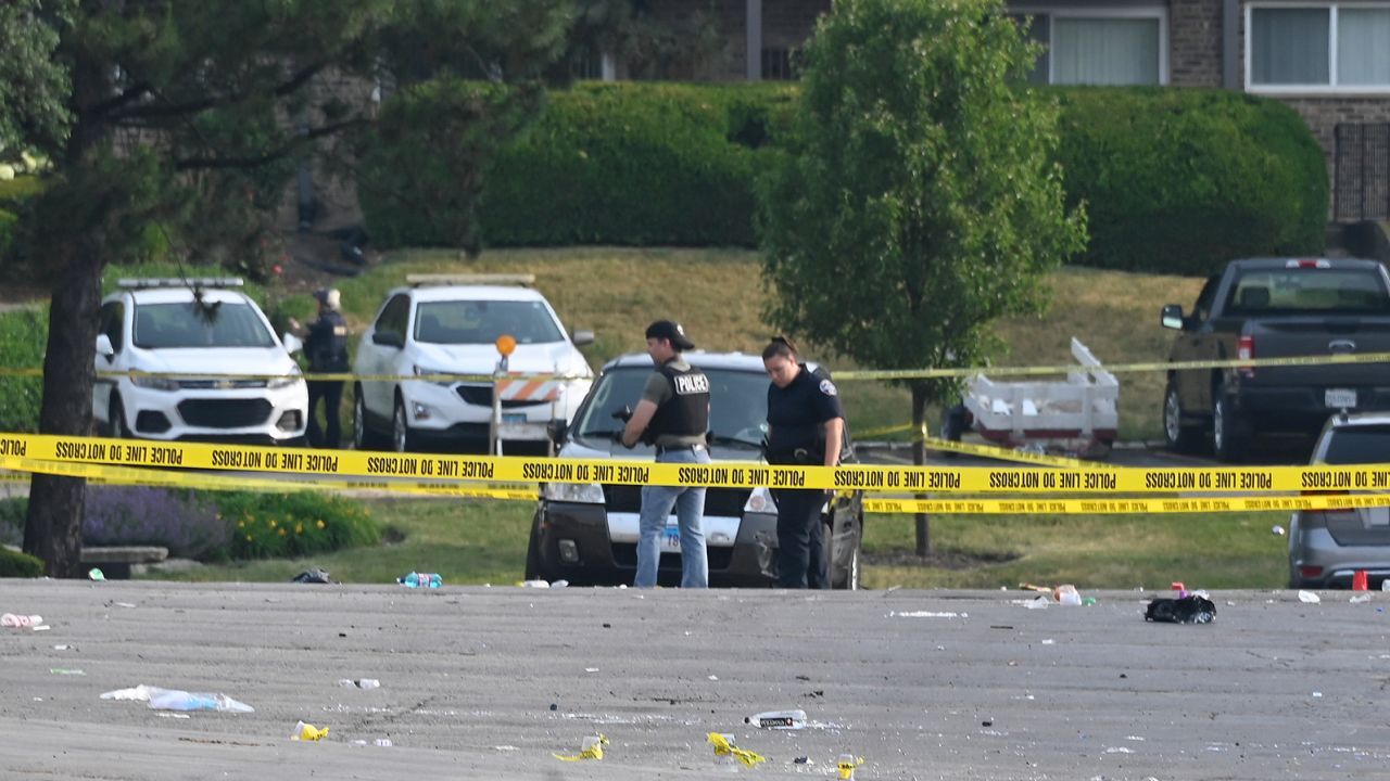 Investigators on Sunday work the scene of a mass shooting in Willowbrook, Illinois.
