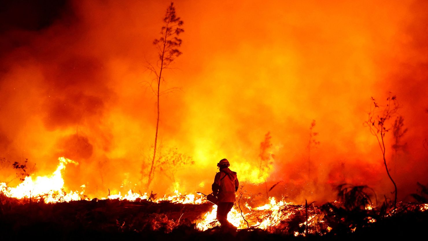 A firefighter creates a tactical fire in Louchats, as wildfires continue to spread in the Gironde region of southwestern France, July 17, 2022.