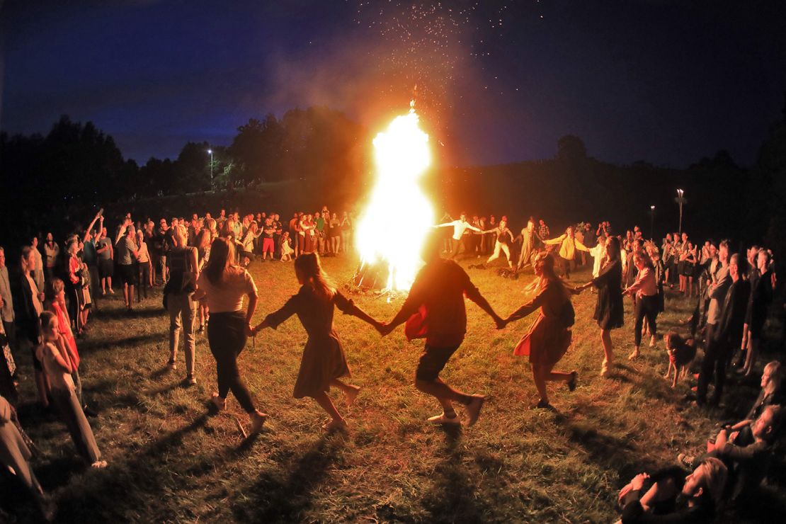 People take part in a traditional mid-summer solstice night celebration (Rasos Festival) at the Open-Air Museum of Lithuania in Rumsiskes, east of Kaunas, Lithuania, on late June 23, 2020. (Photo by PETRAS MALUKAS / AFP) (Photo by PETRAS MALUKAS/AFP via Getty Images)