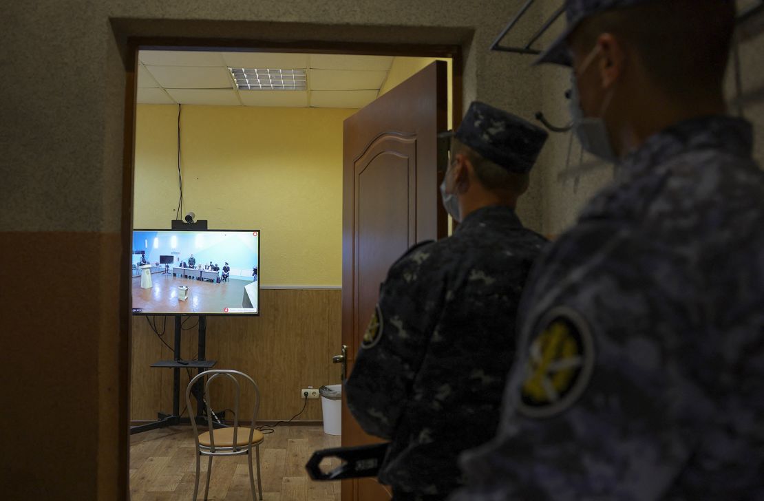 Law enforcement officers watch a video link of Navalny's hearing on June 19.
