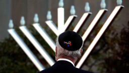 Rabbi Jeffrey Myers watches the installation of a menorah outside the Tree of Life Synagogue before holding a celebration on the first night of Hanukkah, Sunday, Dec. 2, 2018, in the Squirrel Hill neighborhood of Pittsburgh. A gunman shot and killed 11 people while they worshipped Saturday, Oct. 27, at the temple. (AP Photo/Gene J. Puskar)