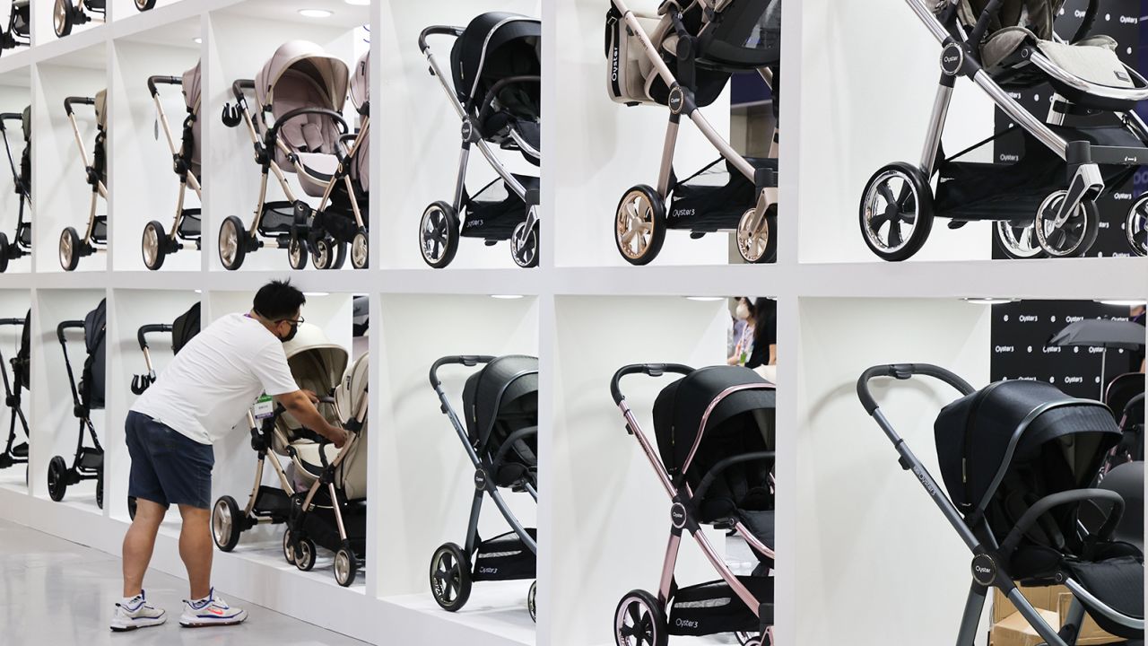 A man looks at prams at a baby fair in Seoul, South Korea, in September 2022. South Korea's fertility rate is the lowest in the world.