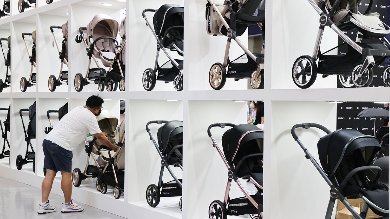 A man looks at strollers at a baby fair in Seoul, South Korea, in September 2022. South Korea's fertility rate is the lowest in the world.