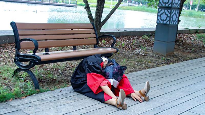        One photo shows the young woman sprawled facedown on the ground in a graduation gown, her tasseled cap discarded to the side. Others show her s