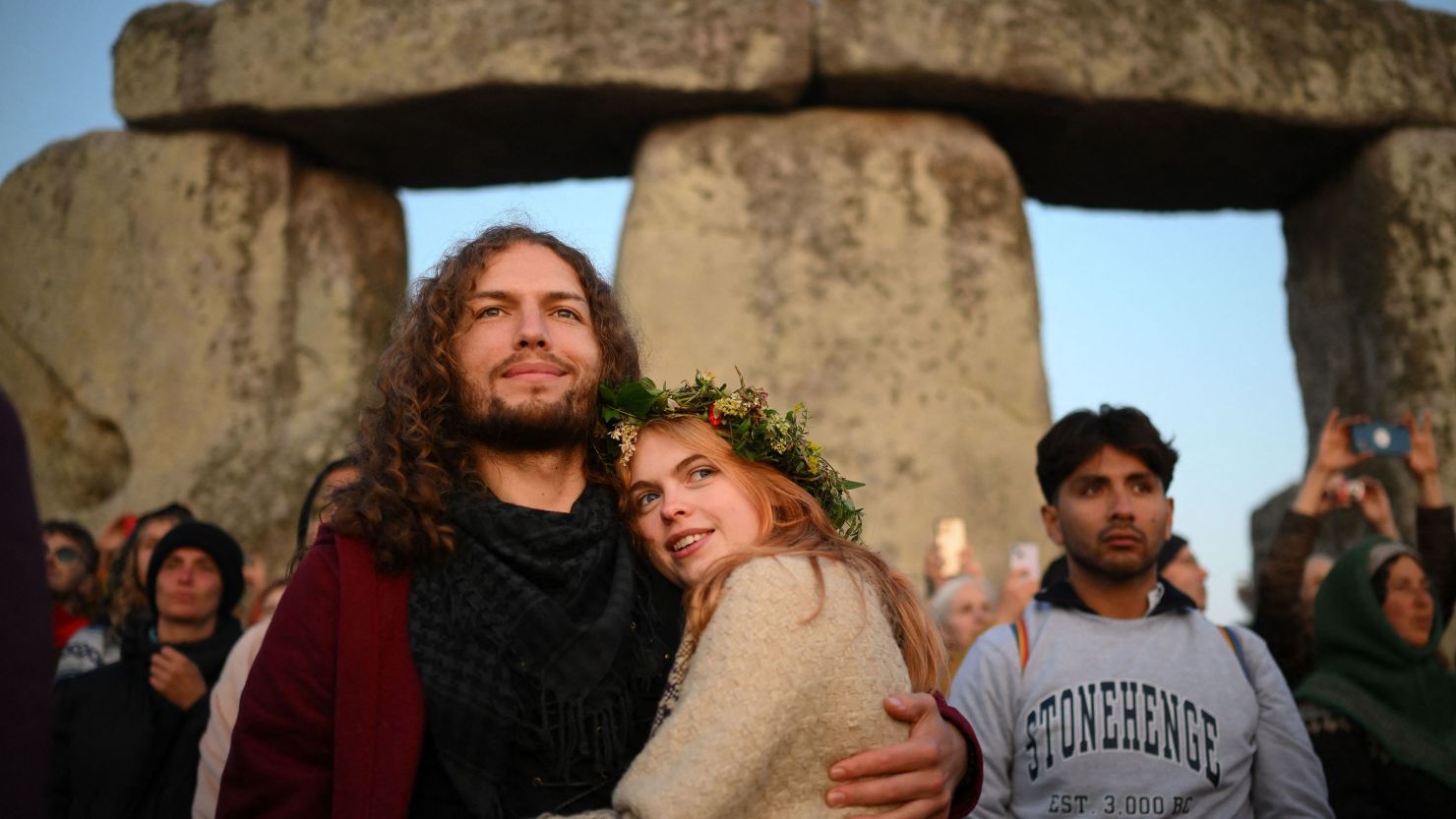 Revellers celebrate the Summer Solstice as the sun rises at Stonehenge, near Amesbury, in Wiltshire, southern England on June 21, 2023, in a festival, which dates back thousands of years, celebrating the longest day of the year when the sun is at its maximum elevation. The stone monument -- carved and constructed at a time when there were no metal tools -- symbolises Britain's semi-mythical pre-historic period, and has spawned countless legends. (Photo by Daniel LEAL / AFP) (Photo by DANIEL LEAL/AFP via Getty Images)