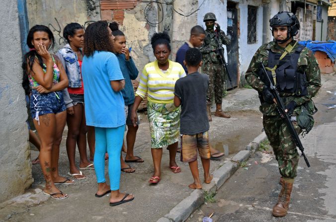 The favela was immortalized in the 2002 film bearing its English name, "City of God." Life there is still dangerous, with police and gangs wrestling for control. Pictured, security forces on patrol in 2018. 