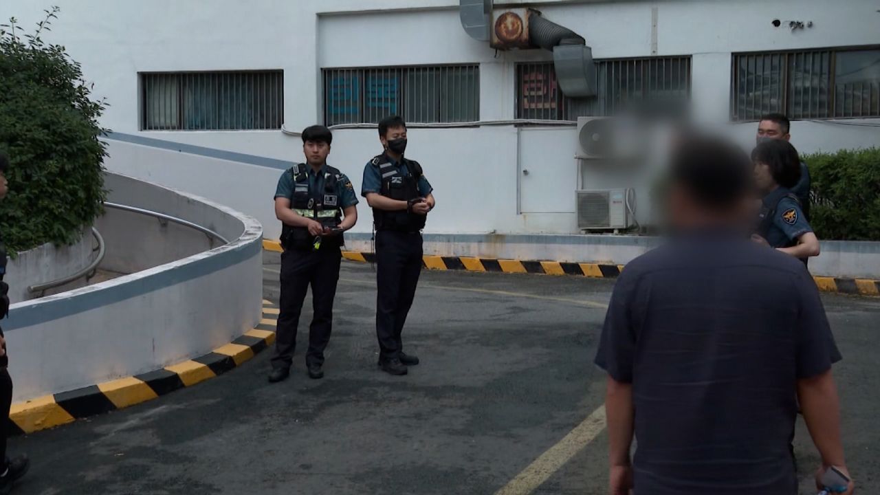 Police officers outside a woman's residence in Suwon, South Korea, where she is suspected of killing her children and keeping their bodies in a freezer.